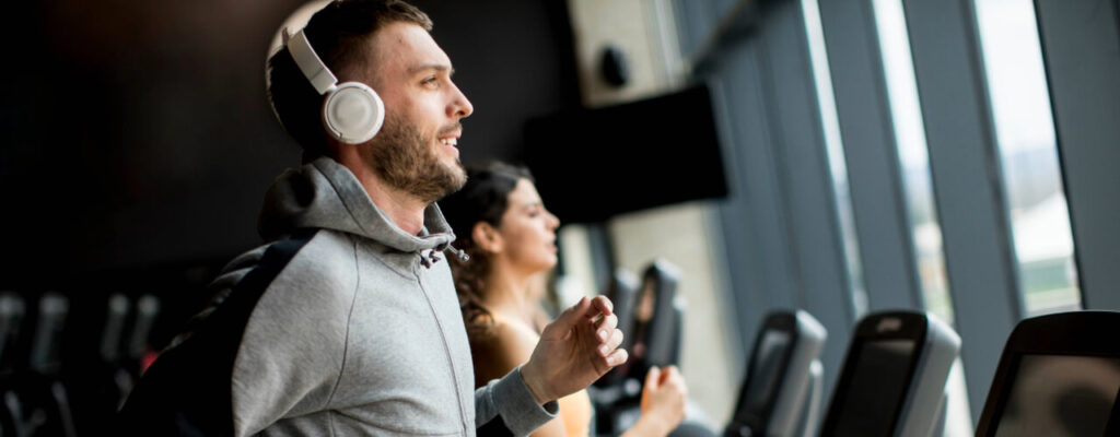 Elevate Your Therapy Routine, Integrating Blood Flow Restriction Into Your Therapy, A Man Runs on A Treadmill With His Headphones On