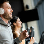 Elevate Your Therapy Routine, Integrating Blood Flow Restriction Into Your Therapy, A Man Runs on A Treadmill With His Headphones On